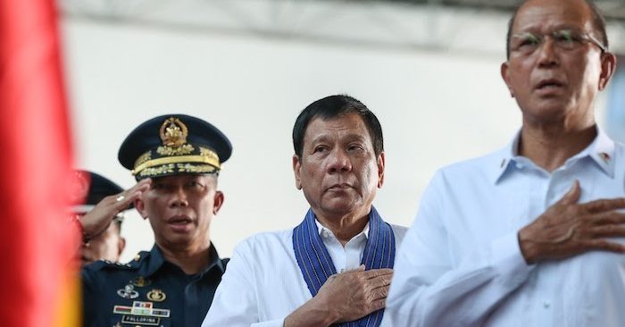 Tổng thống Rodrigo Duterte (giữa) cùng với Tư lệnh Không quân Philippines Trung tướng Edgar Fallorina (trái) và Bộ trưởng Quốc phòng Delfin Lorenzana, hát quốc ca trong nghi thức khai mạc lễ kỷ niệm ngày thành lập lực lượng không vận của Tổng thống tại căn cứ không quân Villamor ở thành phố Pasay ngày 13/9/2016.